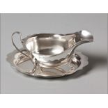 A 20TH CENTURY SILVER GRAVY BOAT SHEFFIELD 1958, E.V. serpentine rim, C-scroll form handle, standing