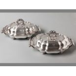 A PAIR OF SILVERPLATE ENTRÉE DISHES with removable embossed handles, cover with serpentine rims