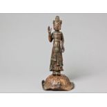 A SOUTH EAST ASIAN COPPER FIGURE OF A PRIEST possibly 19th century or earlier, the dress elaborately