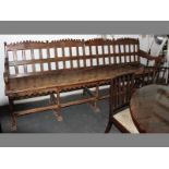 A 19TH CENTURY CONTINENTAL CHESTNUT CHURCH PEW, 275cm long