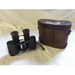 A pair of ministry of defence World War I binoculars with arrow markings and the word Paris.