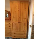 A pine double wardrobe with two drawers below.