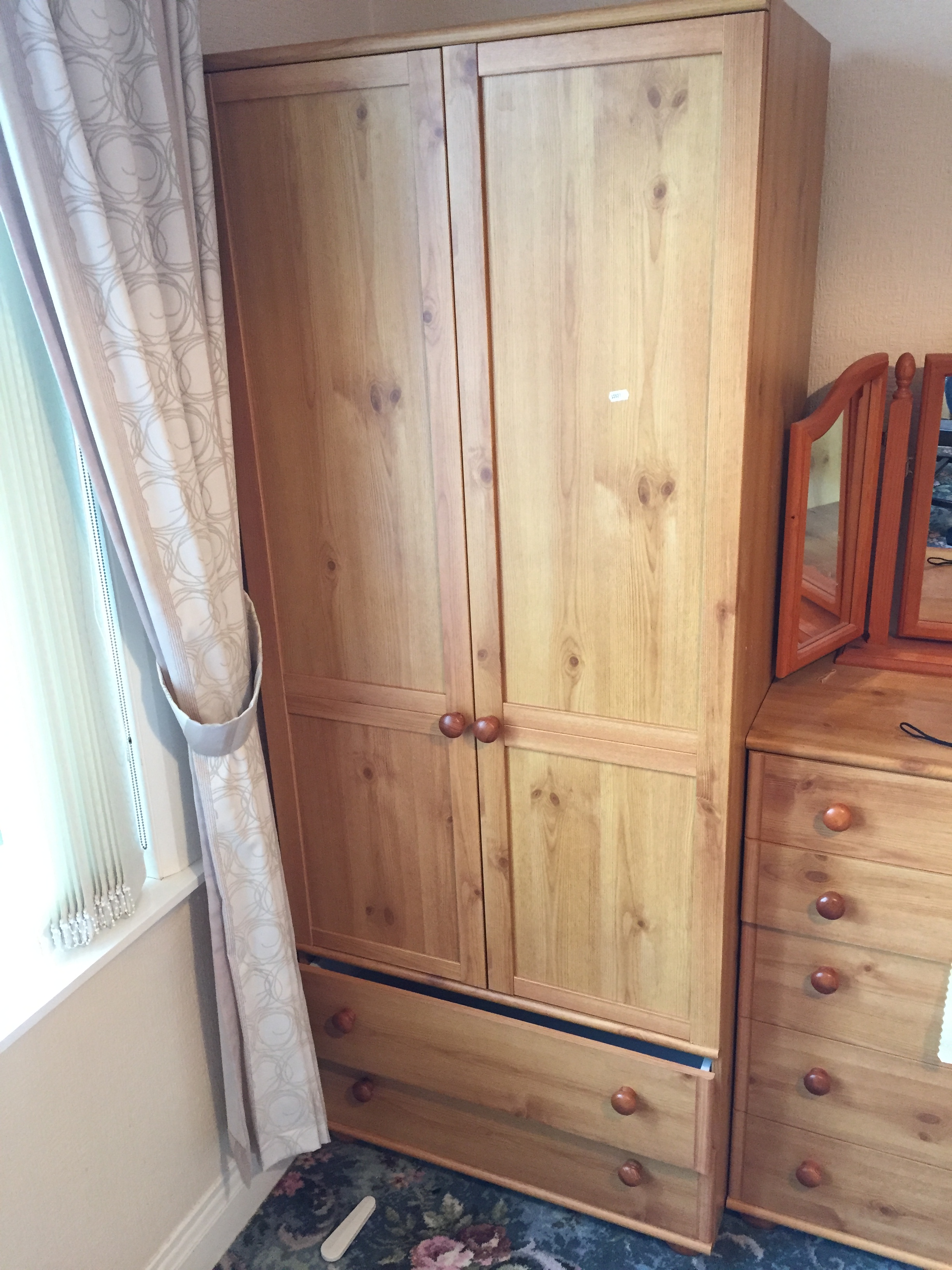 A pine double wardrobe with two drawers below.