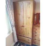 A pine double wardrobe with two drawers below.