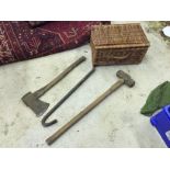 An axe a sledgehammer a crow bar and a wicker basket.