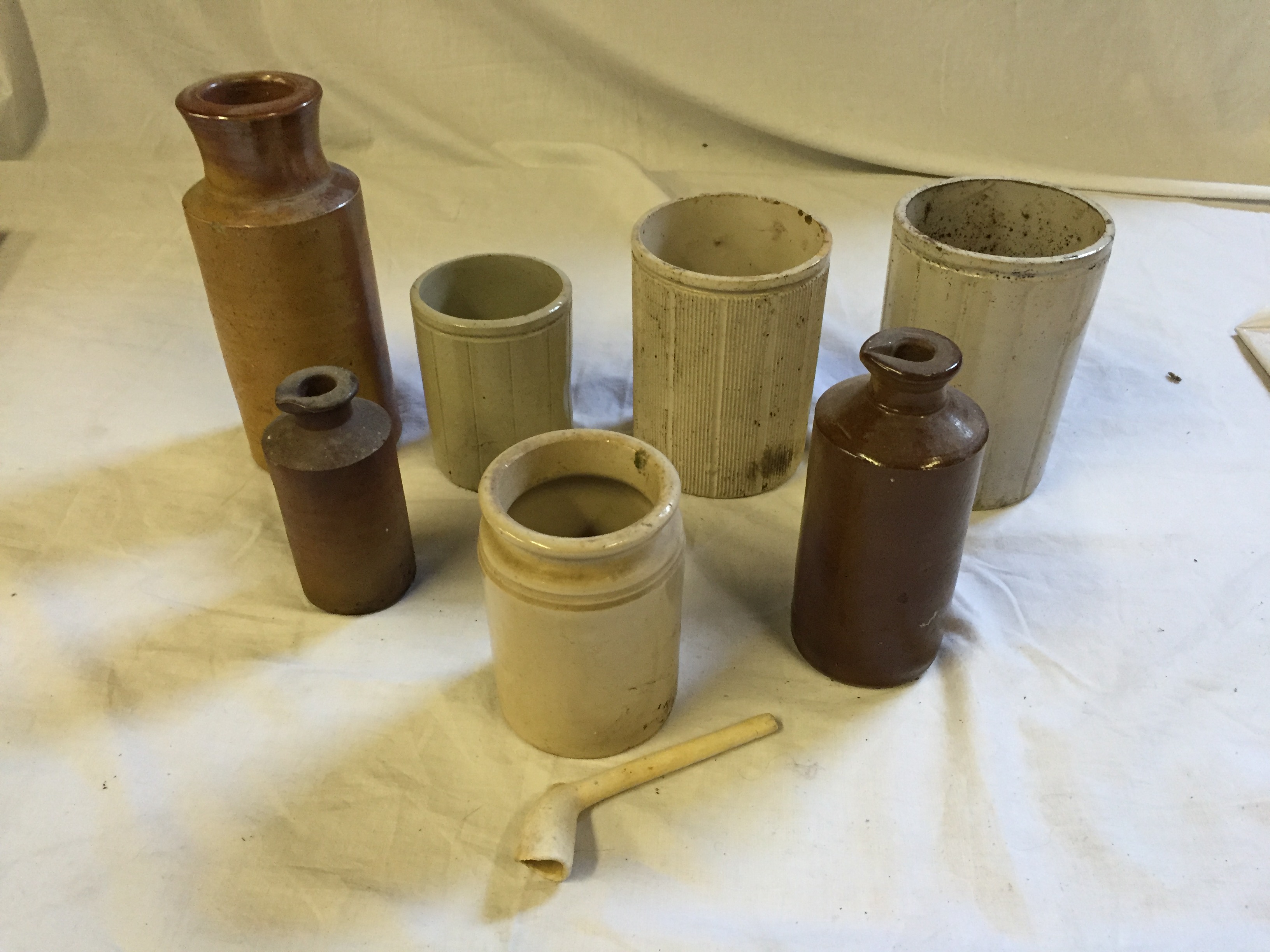 Stoneware ink bottles and other stoneware pots and a clay pipe.