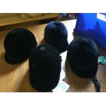 Four riding hats sizes as shown unused.