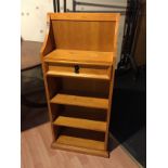 A pine bookcase with single drawer.