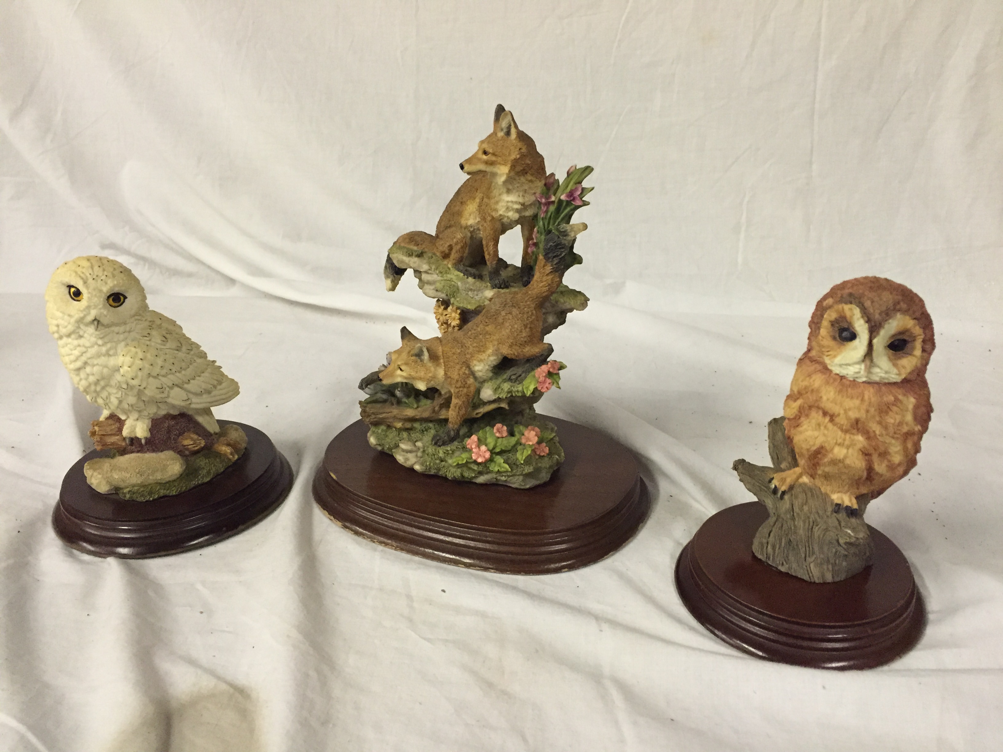 Two collectable owls and a figure of two foxes