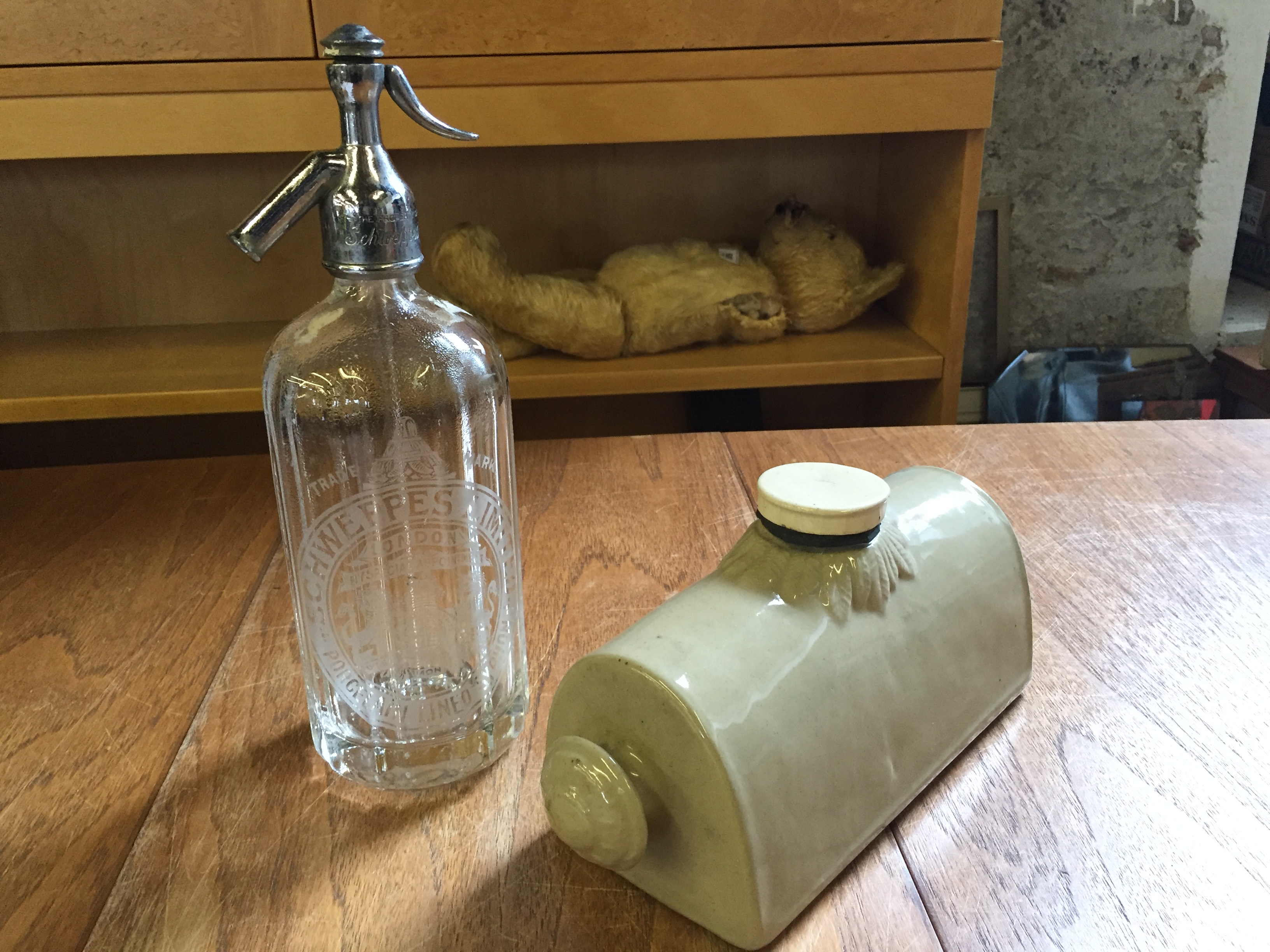 A vintage Schweppes soda siphon and a hot water pig.