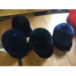 Four riding hats sizes as shown unused.