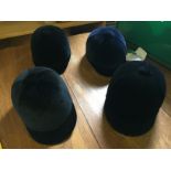 Four riding hats unused sizes as shown.