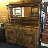 A magnificent oak Arts and Crafts mirror backed sideboard with the mirror having a canopy above and