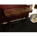 A Victorian walnut topped games table with chess board to top on turned mahogany feet with central