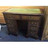 A small pedestal desk with green leather top and two long drawers with three drawers to each