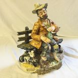 A Capodimonte figure of tramp with dog drinking gin.