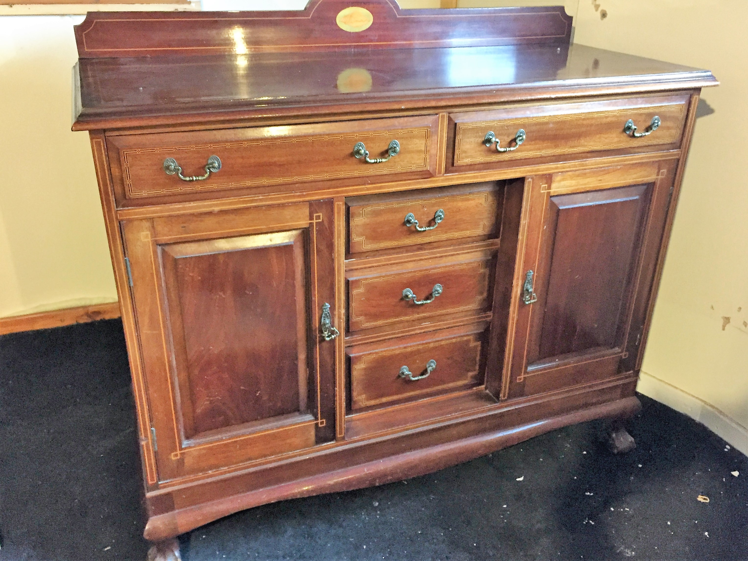 A sideboard with two drawers over two side cupboards and three central drawers.