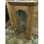 A Georgian oak corner cabinet with glass door and replacement glass shelving.
