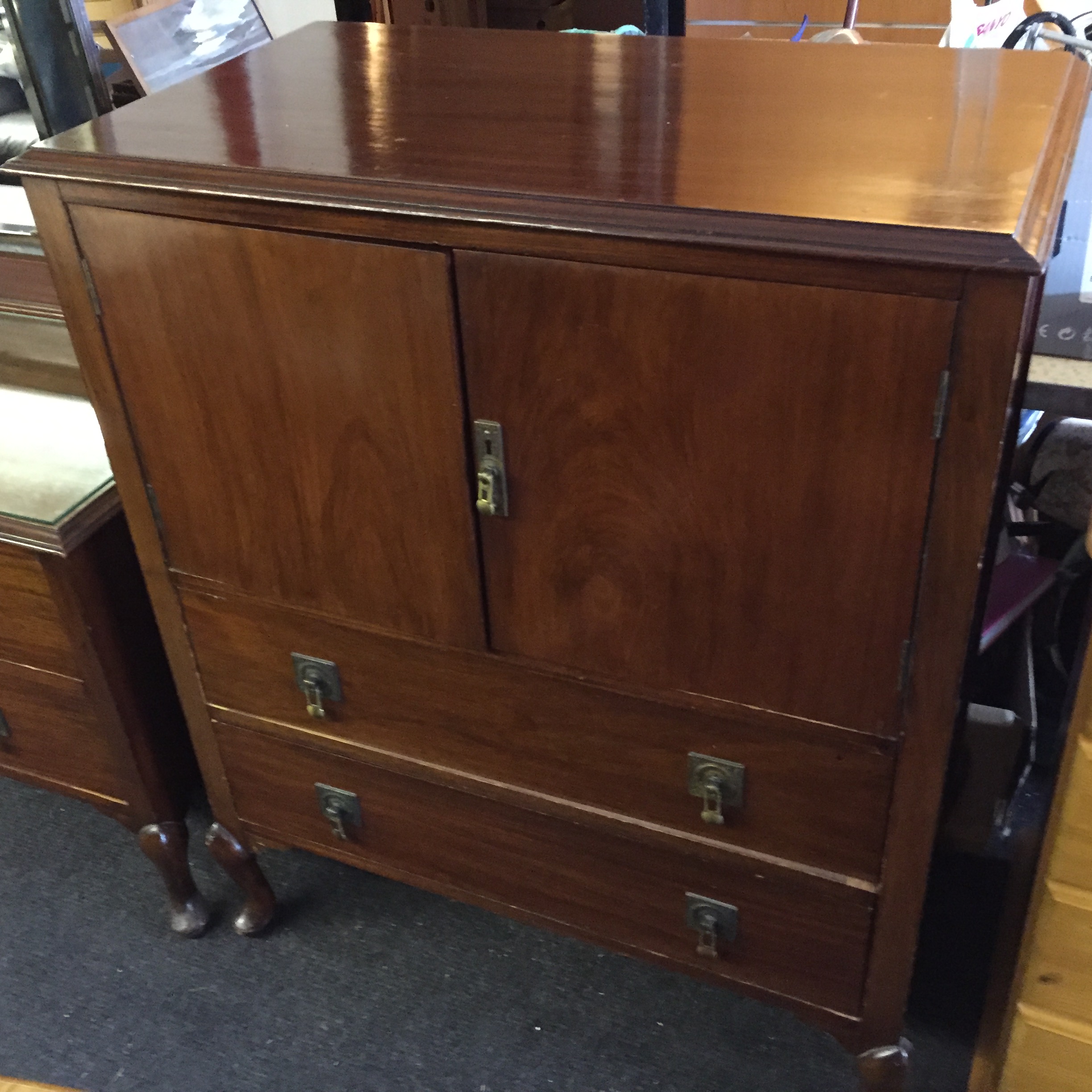 A linen cupboard with two doors over two drawers.