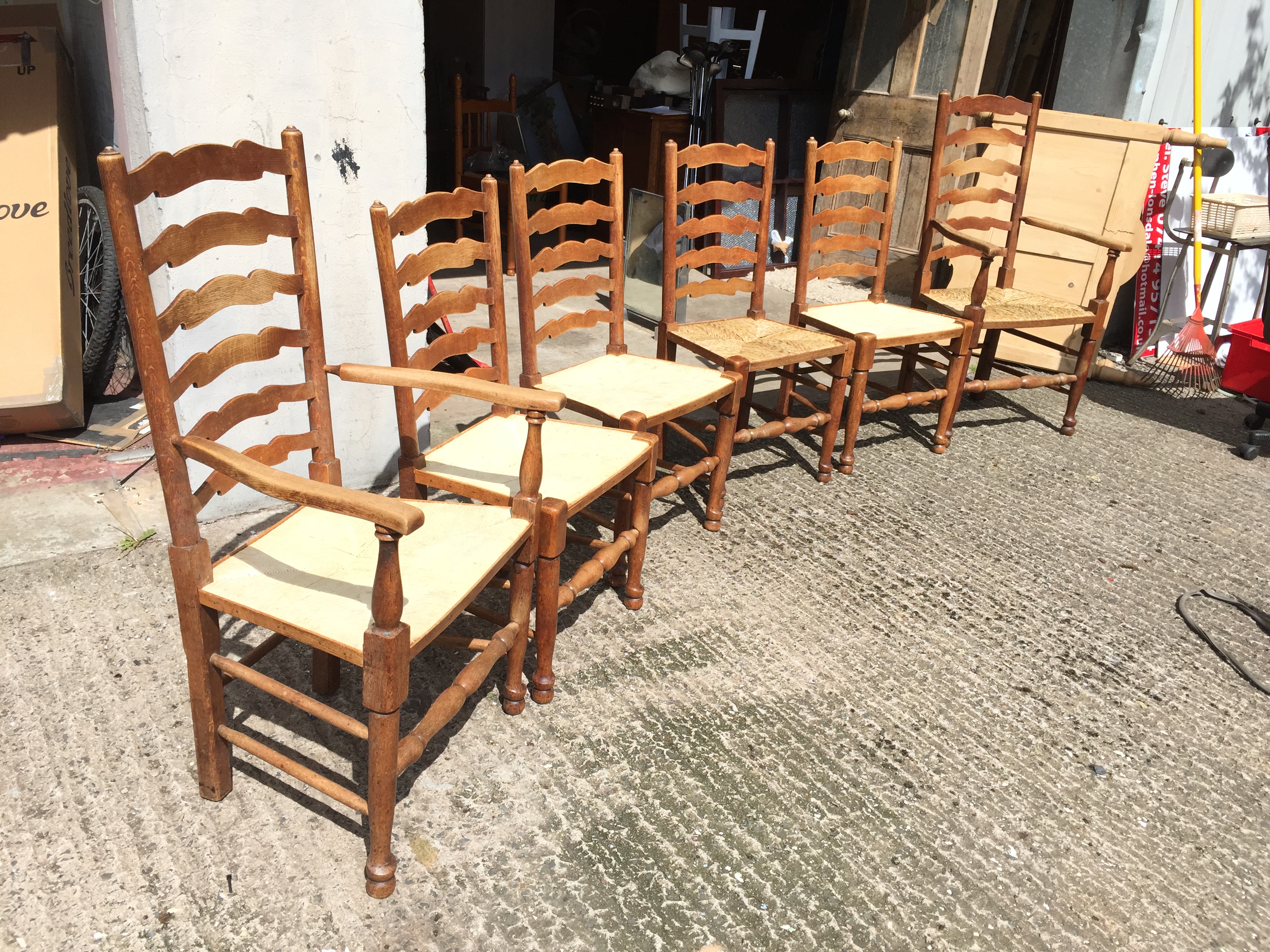 *A set of six oak ladder back dining chairs with rush seats two newly refurbished.