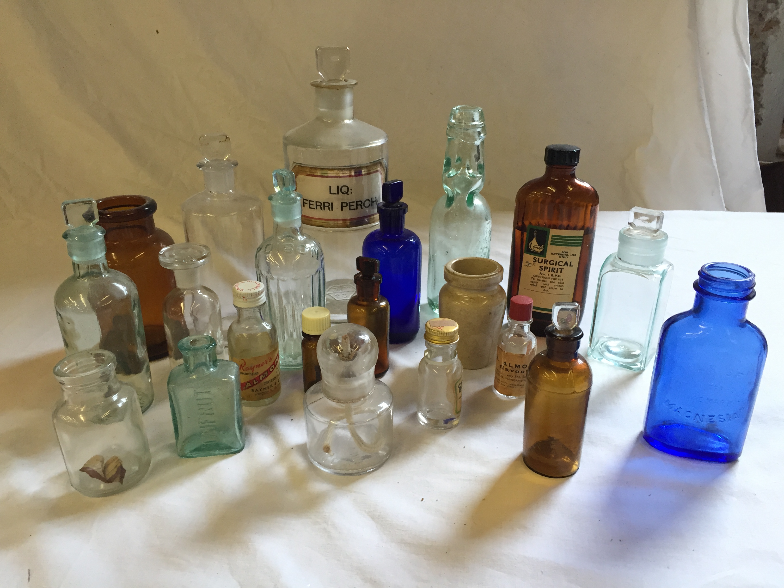 Twenty one glass bottles including clear chemist bottle, blue glass and brown.