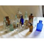 Twenty one glass bottles including clear chemist bottle, blue glass and brown.