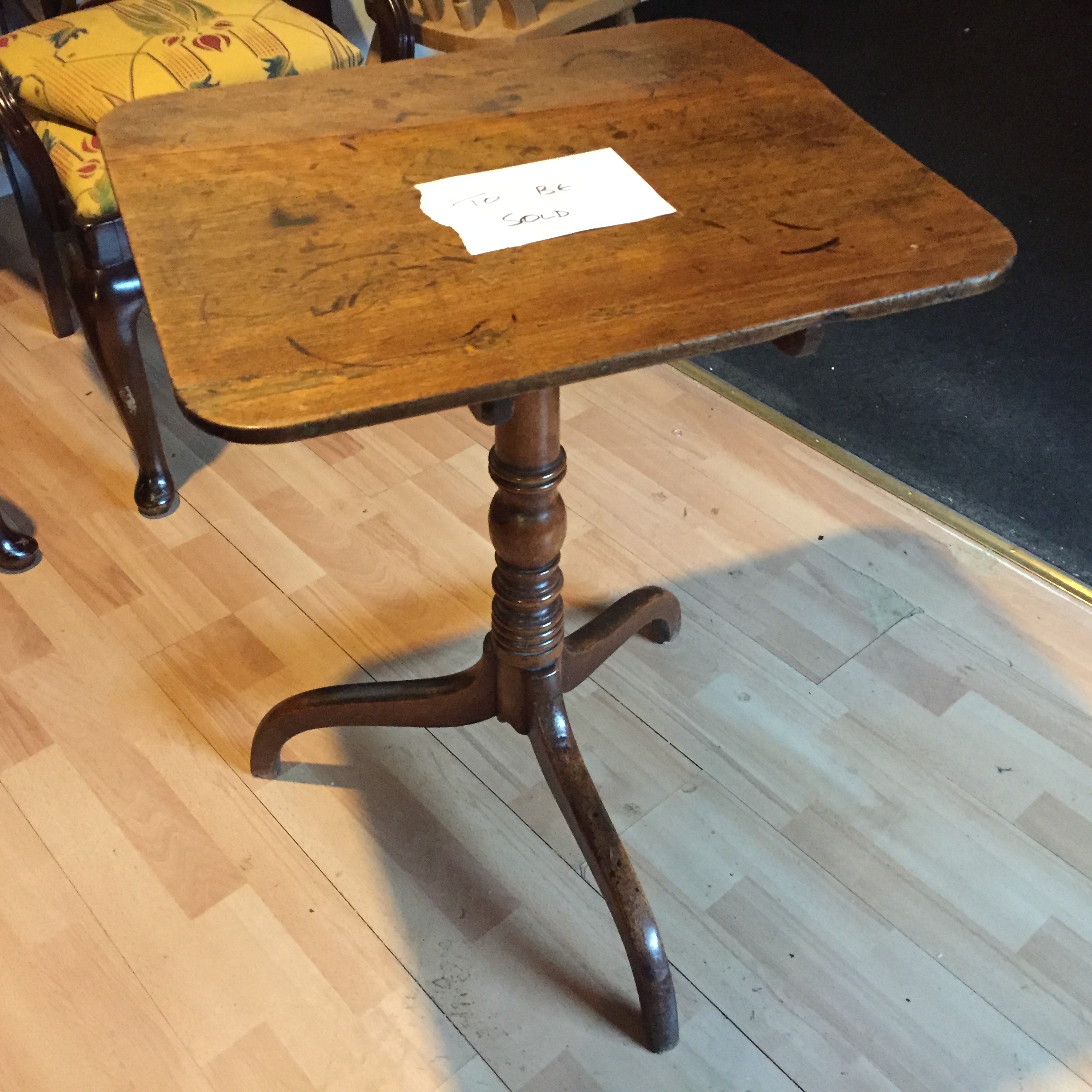 A small oak tilt top wine table.