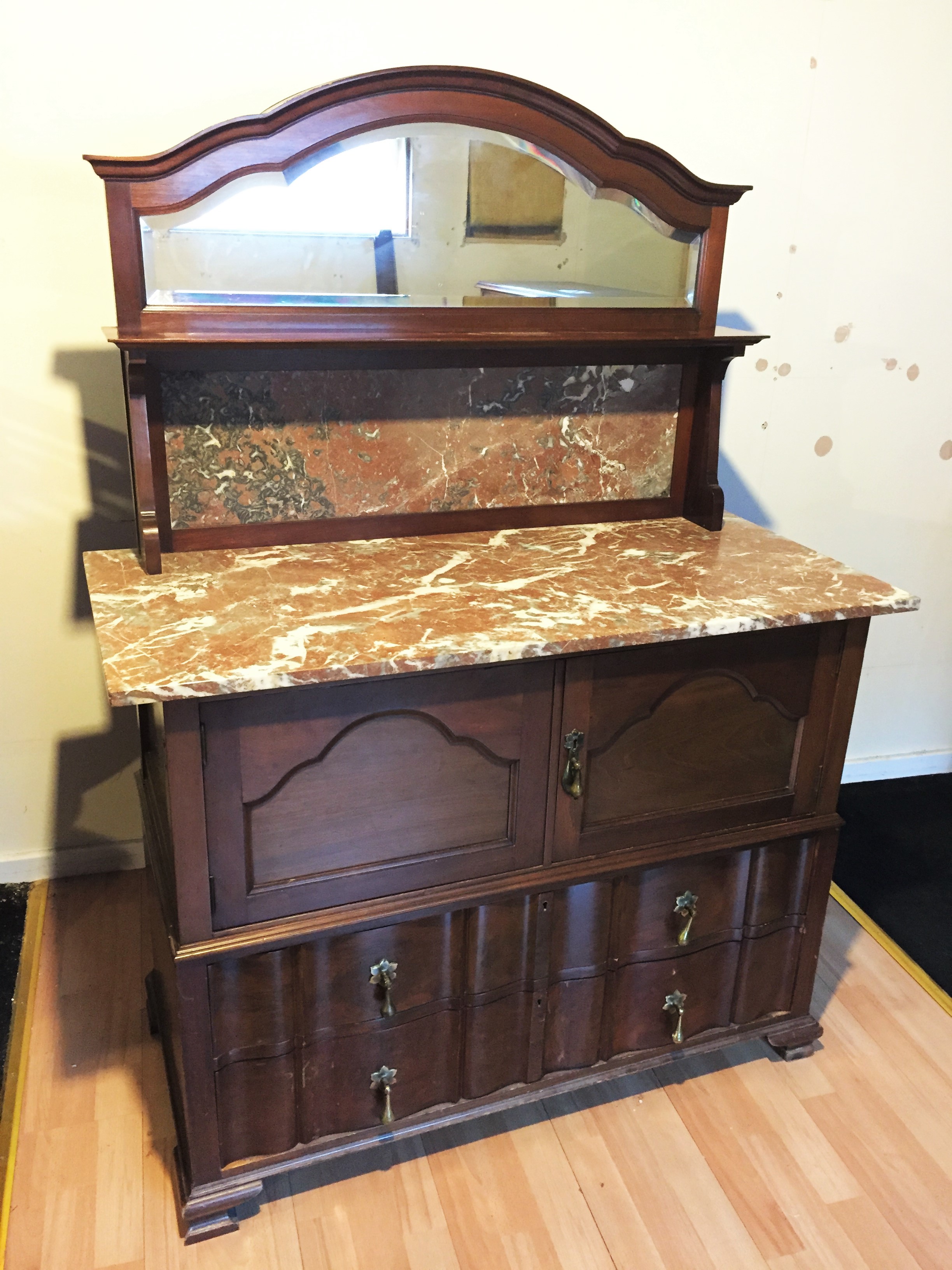 A mirror backed marble topped wash stand with cupboard above two drawers.