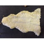 A Sheepskin rug with straps to use a a piney.