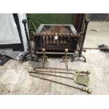 A pair of rams head fire dogs, a fire grate and a brass companion set with dogs.