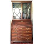 A Georgian bookcase bureau having glazed astral doors to the bookcase top and fitted desk area with