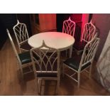 A circular extending dining table and six cane cathedral back chairs.