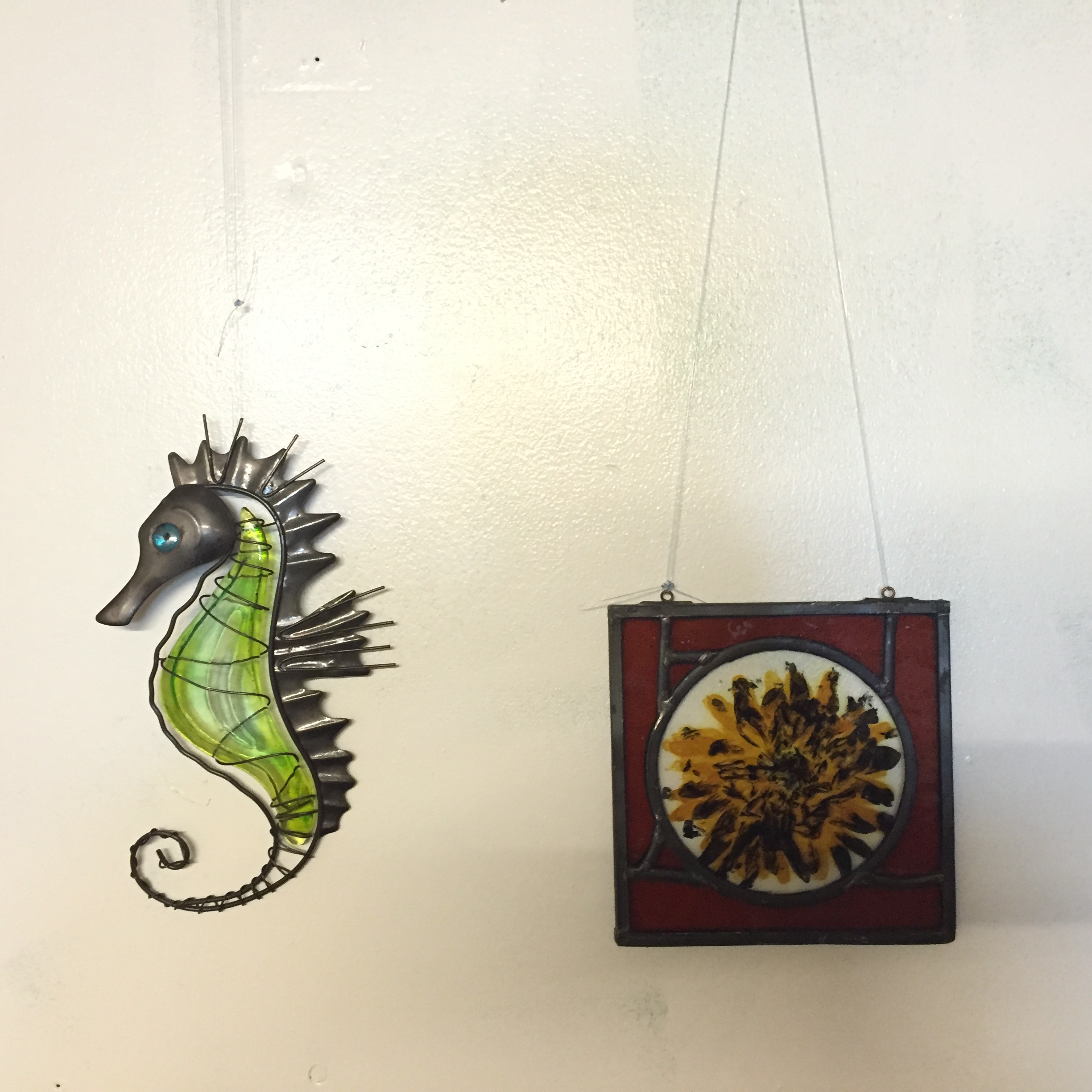 A stained glass sea horse and decorative plaque.