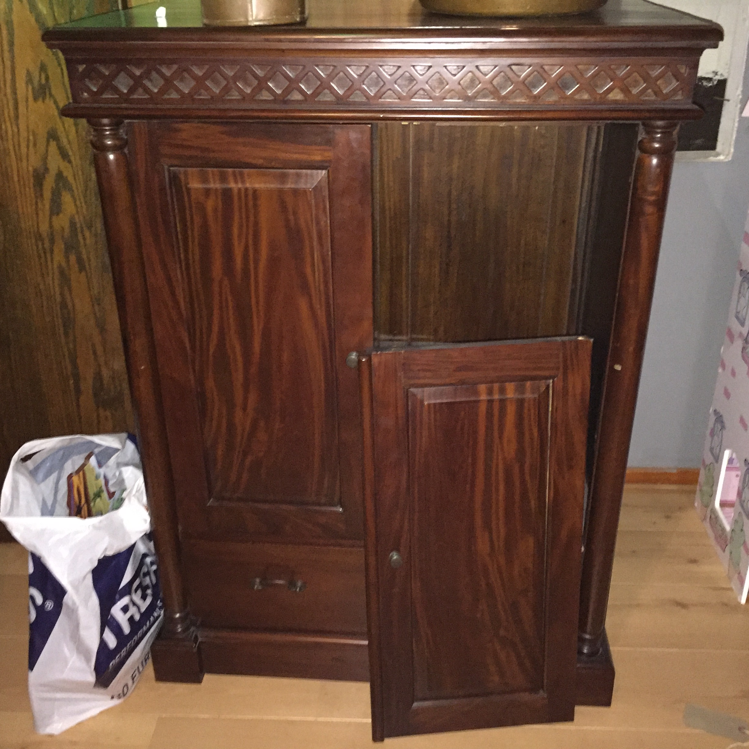 A dark wood television cabinet with drawer beneath. Needs slight repair to door.