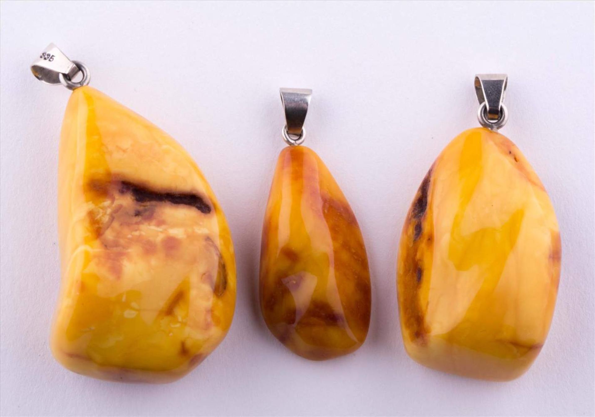 Konvolut Bernstein Anhänger / Group of amber pendants 3 Anhänger, zusammen 27 g, 835/000 Silber /