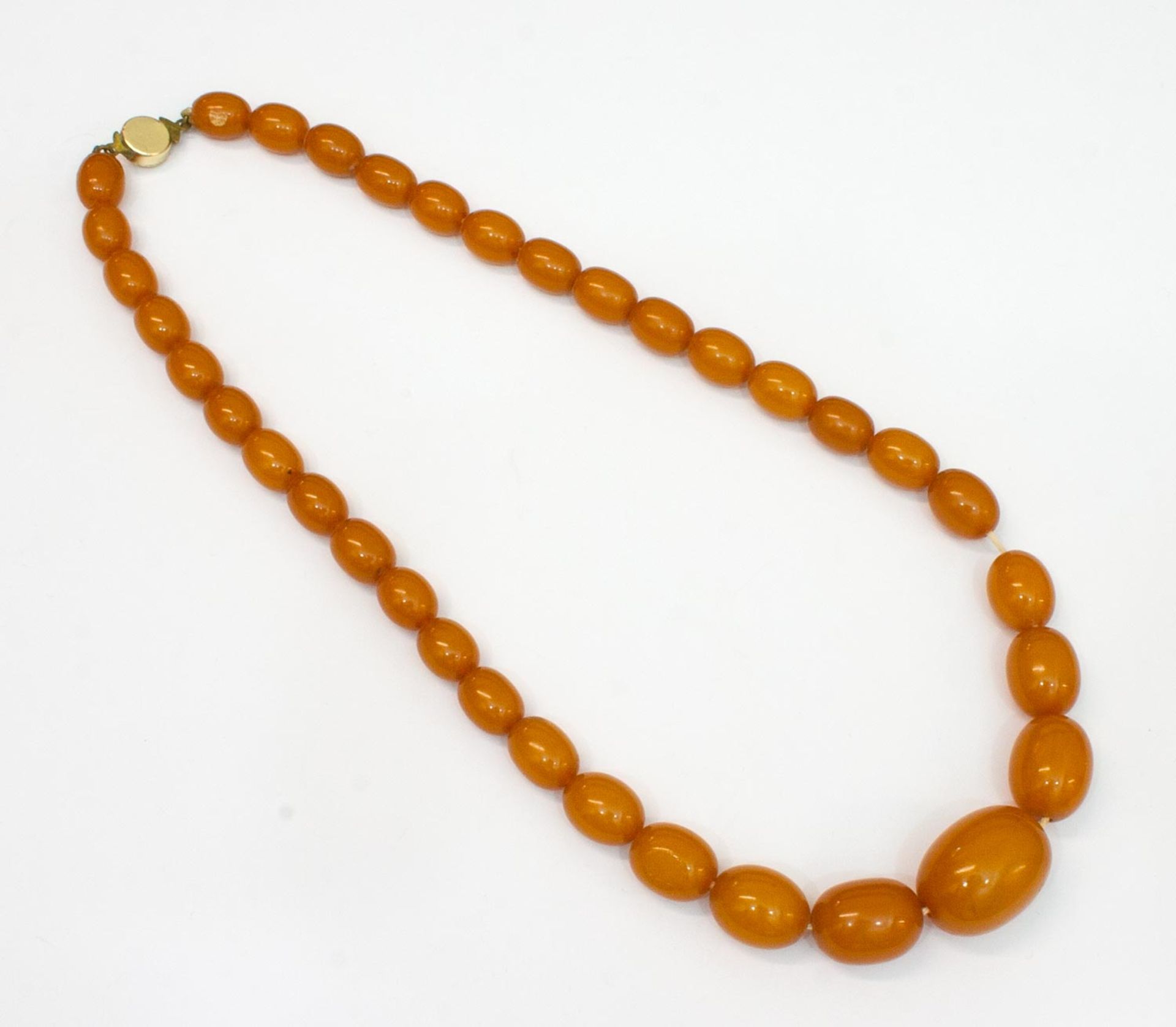 Kette unregelmäßige ovale bernsteinfarbene Perlen, im Verlauf, Steckverschluß, L. 44 cm