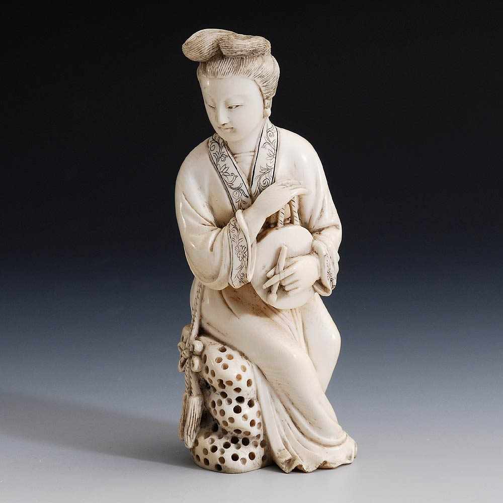 Okimono - Musikerin. Elfenbein, China um 1920. Auf einem Stein sitzende junge Frau mit einem