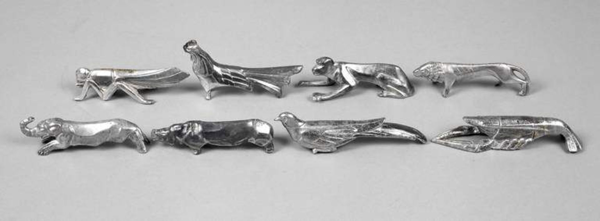 Acht Messerbänkchen Frankreich, um 1930, Zinn versilbert, stilisierte Tierfiguren als Hahn,