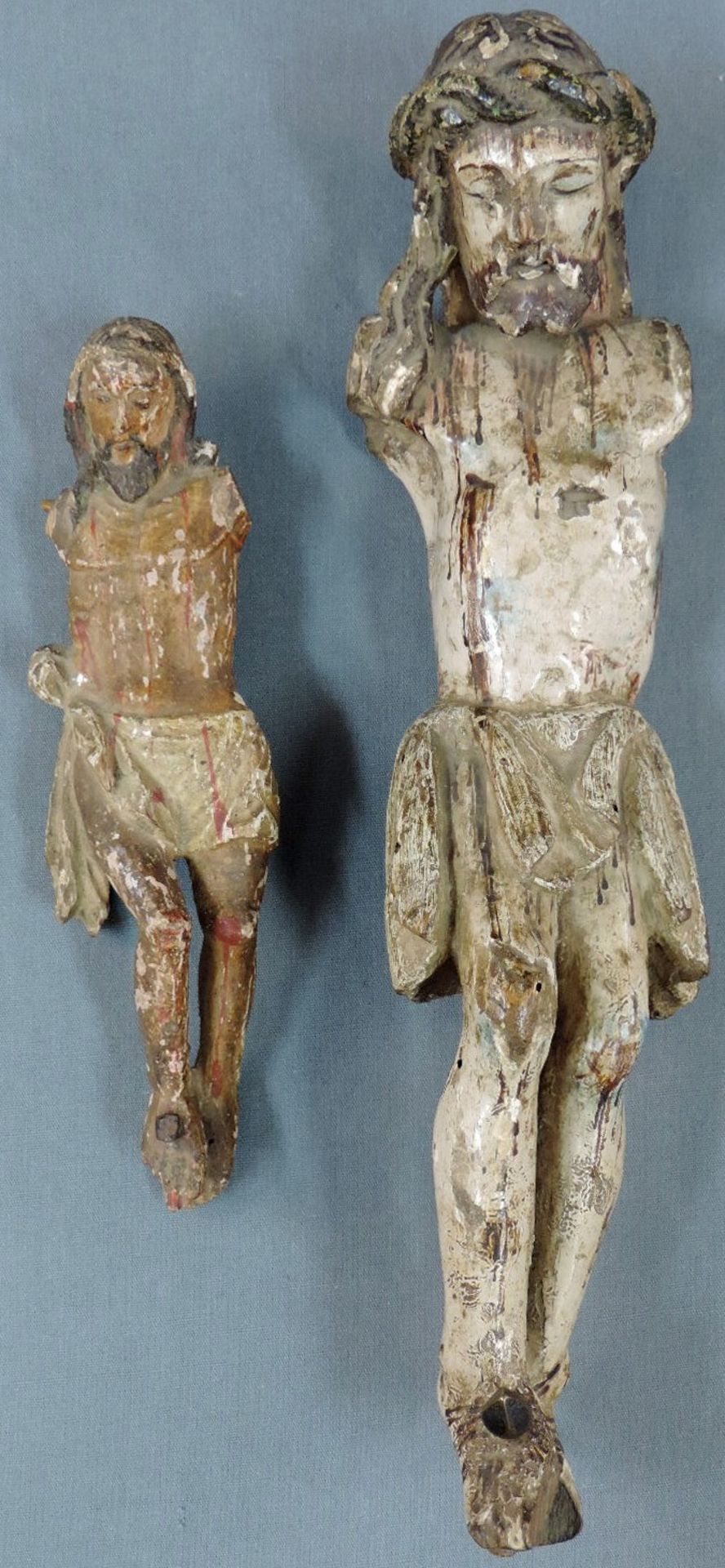 2 Skulpturen des Jesus.21 cm und 36 cm hoch. Holz, geschnitzt und farbig gefasst, Fehlstellen. Nägel