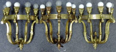 3 Wandlampen aus Messing, um 1900.Circa 51 cm lang, circa 45 cm breit.Bei einer Lampe fehlt der