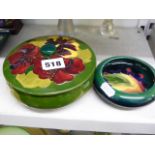 An original Moorcroft powder bowl and cover decorated with hibiscus on a green ground, 5.6 ins