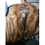 A light brown mink fur long jacket with wide cuffs and lapels  (upstairs rail by silver shelves)