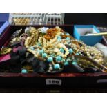 An old leather box full of costume jewellery, mainly beads but including a small cloisonné ball, a