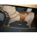 A child's rocking horse with plush body and leatherette saddle and reins.