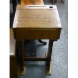 An early 20th century pine school desk with hinged lid inkwell and pen rest.