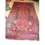 An Eastern rug, the blue ground with three bright red hexagons within multi borders (hall)