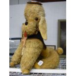 A charming musical poodle by Merrythought with wind up tail and matching hat and fleece outfit in