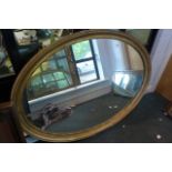 A large oval 19th century mirror gilt framed with beadwork decoration.