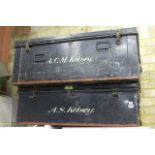 A pair of early 20th century black metal cabin trunks with 'Union Castle Line' and other labels.