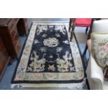 A Chinese woollen rug, the black ground embossed with dragons within floral borders. (Floor by Lot